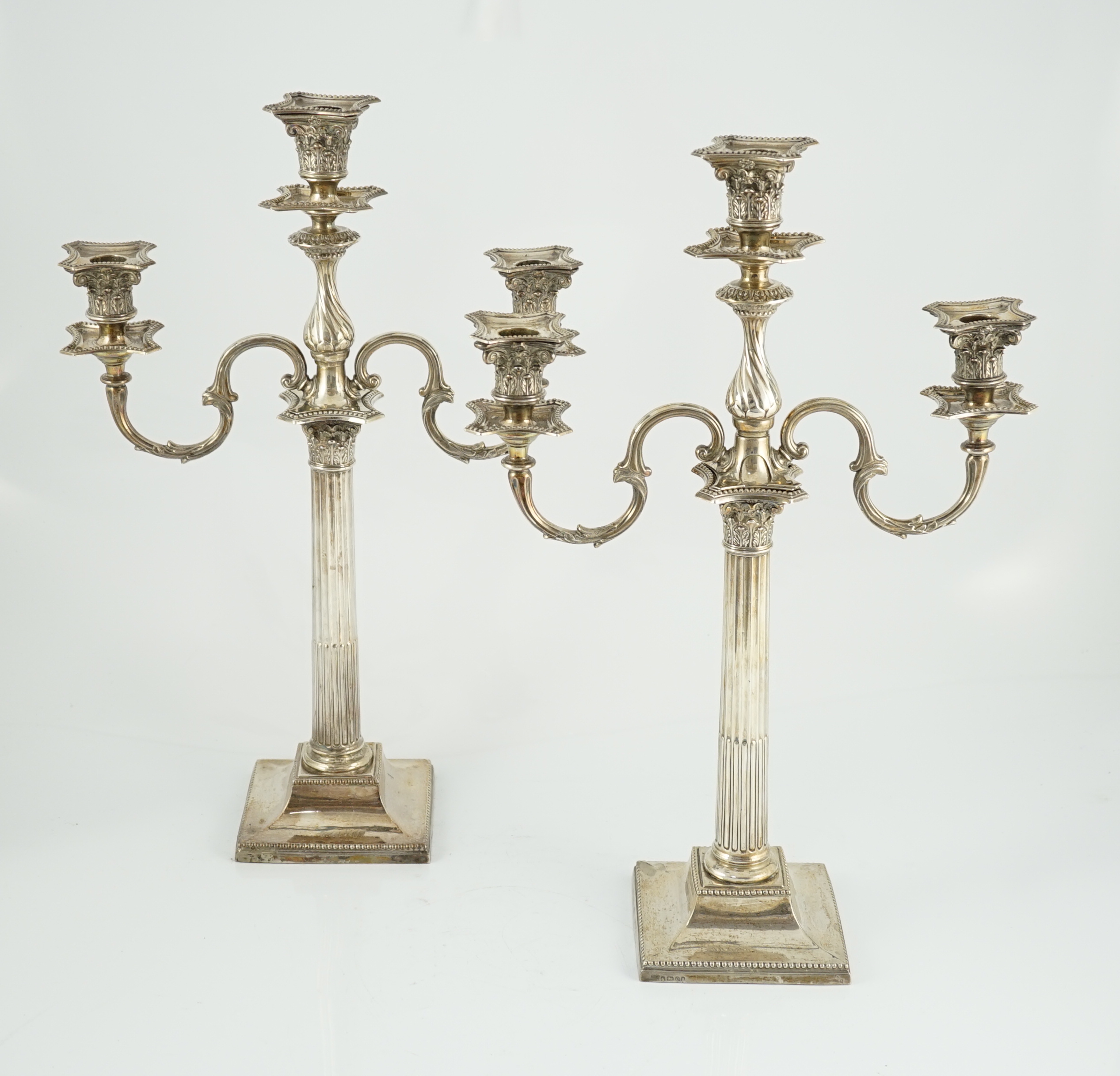 A matched pair of late 19th/early 20th century silver two branch, three light candelabrum